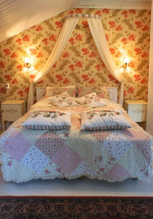 a bedroom with a bed with a quilt on it at Pehtoorin Kammarit in Iltasmäki