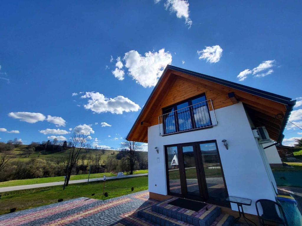 uma pequena casa com telhado de madeira em Domek Bieszczadzki Staw - Noclegi Czarna em Czarna