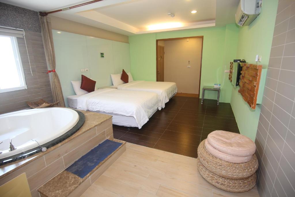 a bedroom with a bed and a bath tub and a bath tub at Kenting Waterfront Hotel in Kenting