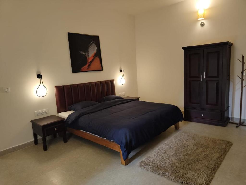 - une chambre avec un lit, une armoire et des lumières dans l'établissement Villa Forever Coorg, à Madikeri