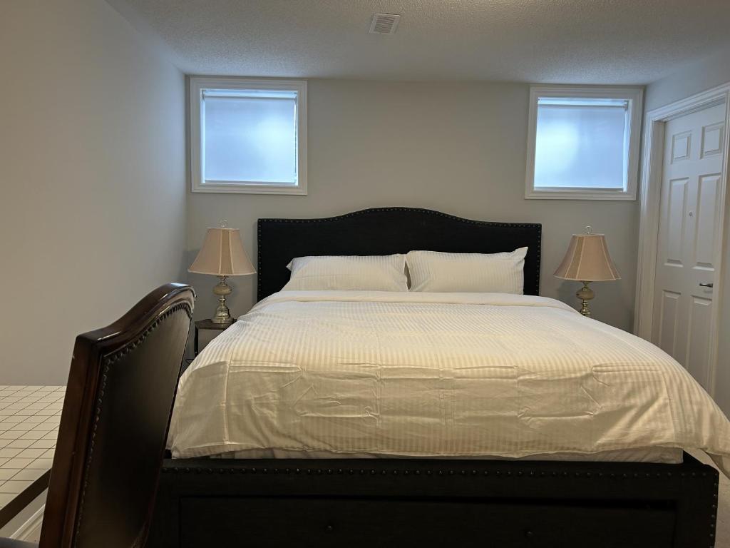 a bedroom with a large bed with two windows at Kolopizo Lounge - Deluxe Studio in Ottawa