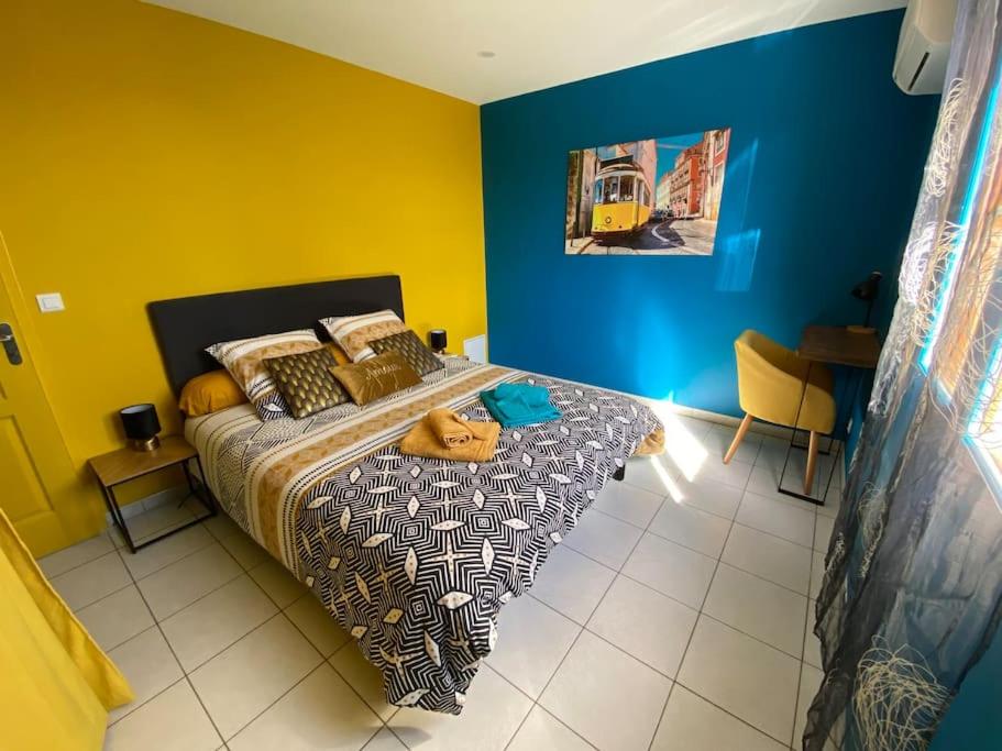 um quarto com uma cama com paredes azuis e amarelas em Gite Combe Ferrade en pleine nature em Campagnac-lès-Quercy