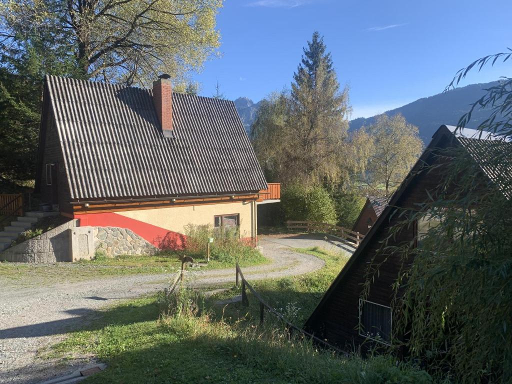 uma casa com um telhado preto na relva em Das kleine Feriendorf em Karnten