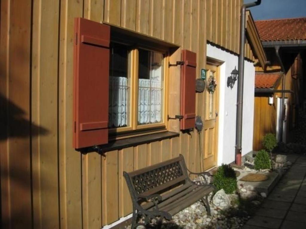 a bench sitting outside of a building with a window at Ferienhaus in ruhiger Lage, mit Balkon und großer Terrasse in Aschau im Chiemgau