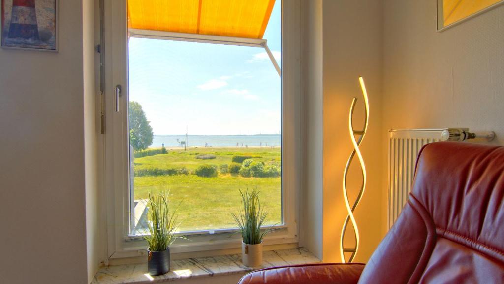 a living room with a window with a view of a field at Dümmer Traum-Traumblick auf dem Dümmersee in Lembruch
