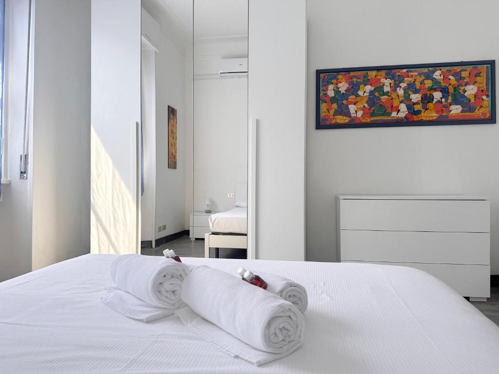 una camera da letto bianca con asciugamani su un letto di BWR - Bellssimo bilocale vicino ai navigli a Milano