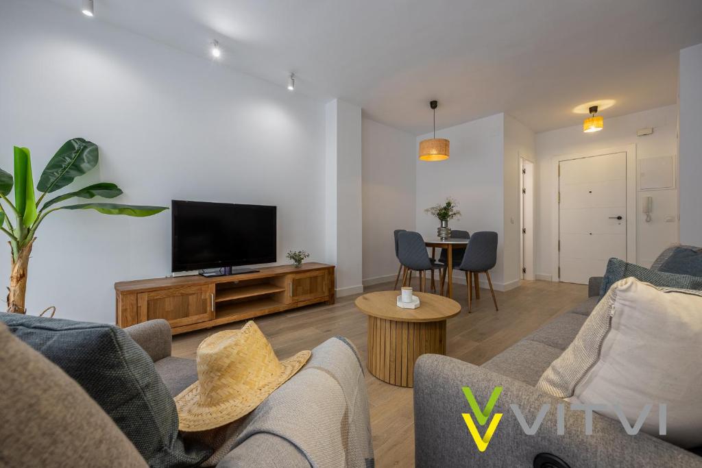 a living room with a couch and a flat screen tv at Vitvi Fuengirola - Premium Reyes in Fuengirola