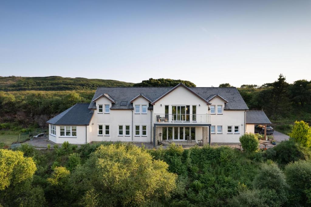 a large white house with a black roof at Killoran House in Dervaig