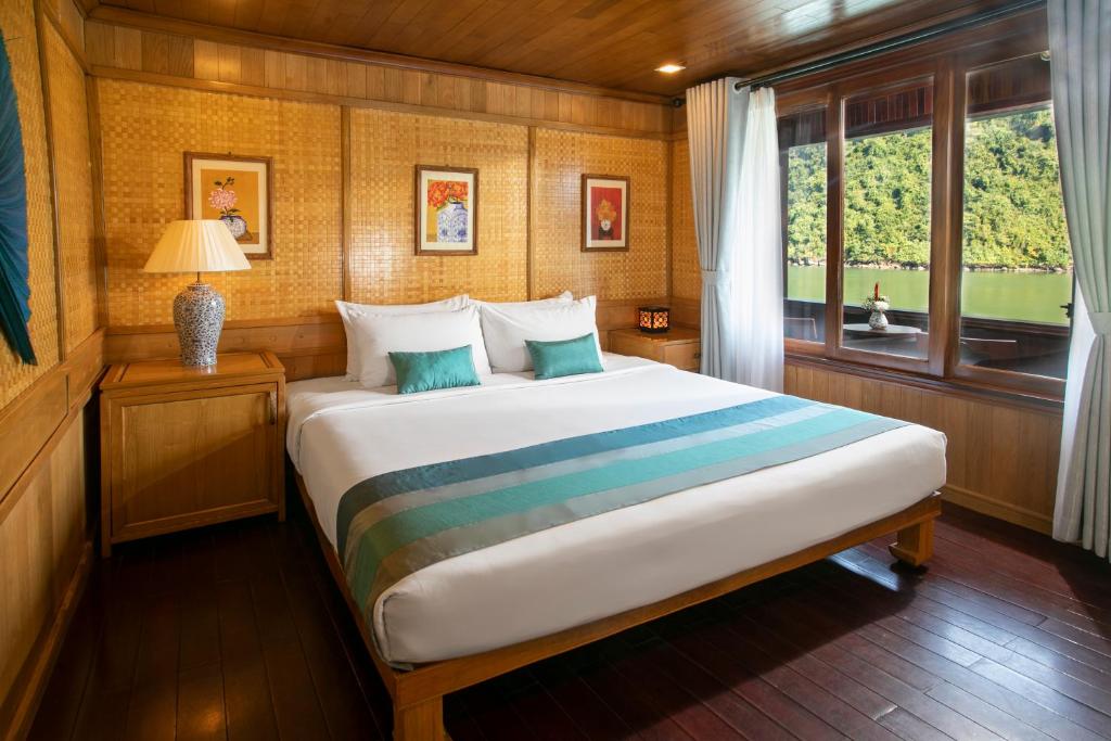 a bedroom with a large bed with a window at Bhaya Halong Cruises in Ha Long