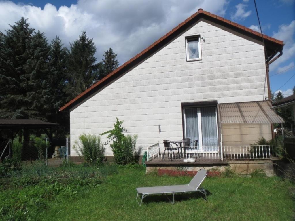 una casa bianca con una panchina davanti di Ferienhaus in ruhiger Lage in der Nähe zahlreicher Wanderrouten, Reitmöglichkeit a Wutha-Farnroda