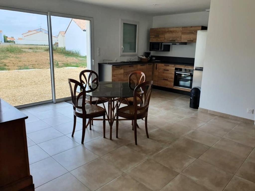 une salle à manger avec une table et des chaises dans une cuisine dans l'établissement MISTRAL ABBA a 500m de la plage, à Saint-Vincent-sur-Jard