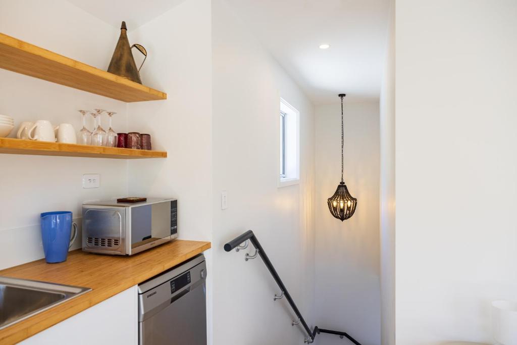 a kitchen with a sink and a microwave on a counter at The Apartment at Arrowtown in Arrowtown