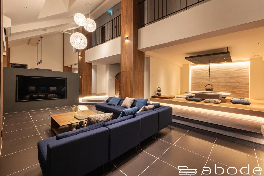 sala de estar con sofá azul y TV en abode villa GORA 八代別邸, en Onsensō