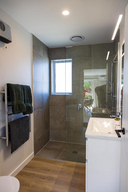 a bathroom with a shower and a sink at The Apartment at Arrowtown in Arrowtown