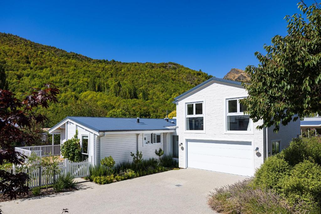 a house with a white garage and a mountain at The Apartment at Arrowtown in Arrowtown