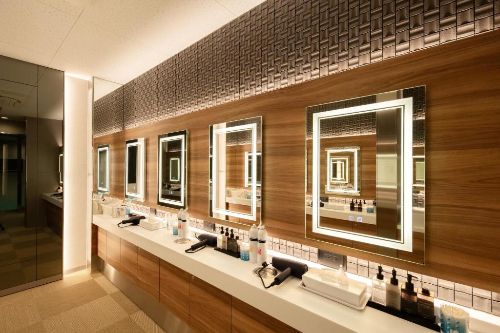 a bathroom with a row of sinks and mirrors at Sauna & Capsule AMZA (mens only) in Osaka