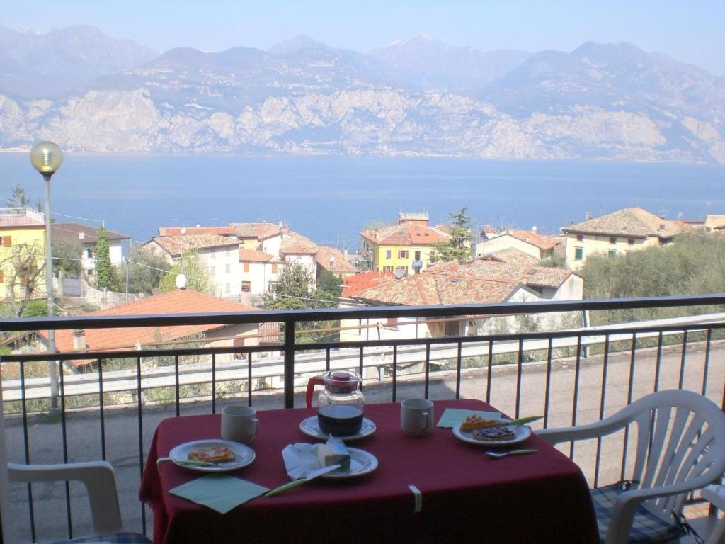 una mesa con platos de comida en la parte superior de un balcón en Gemütliche Ferienwohnung in Cassone Di Malcesine mit Garten, en Malcesine