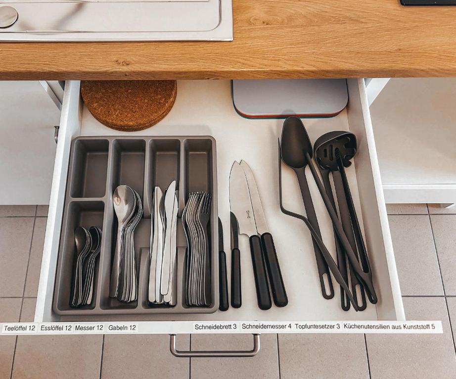 a drawer filled with utensils underneath a kitchen counter at Pinova in Karlsruhe