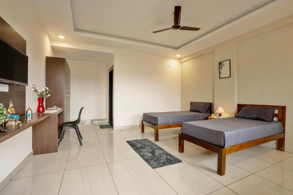 1 Schlafzimmer mit 2 Betten, einem Schreibtisch und einem Stuhl in der Unterkunft Wandr Scorpious - Manyata tech park in Bangalore