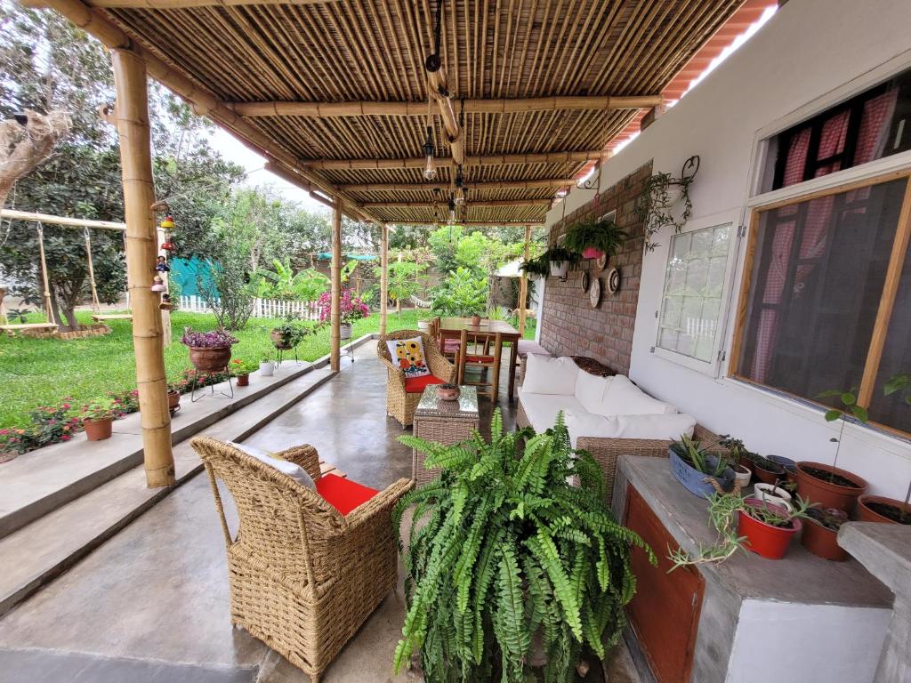 um pátio exterior com cadeiras, mesas e plantas em Casa Huerta em Chincha Alta