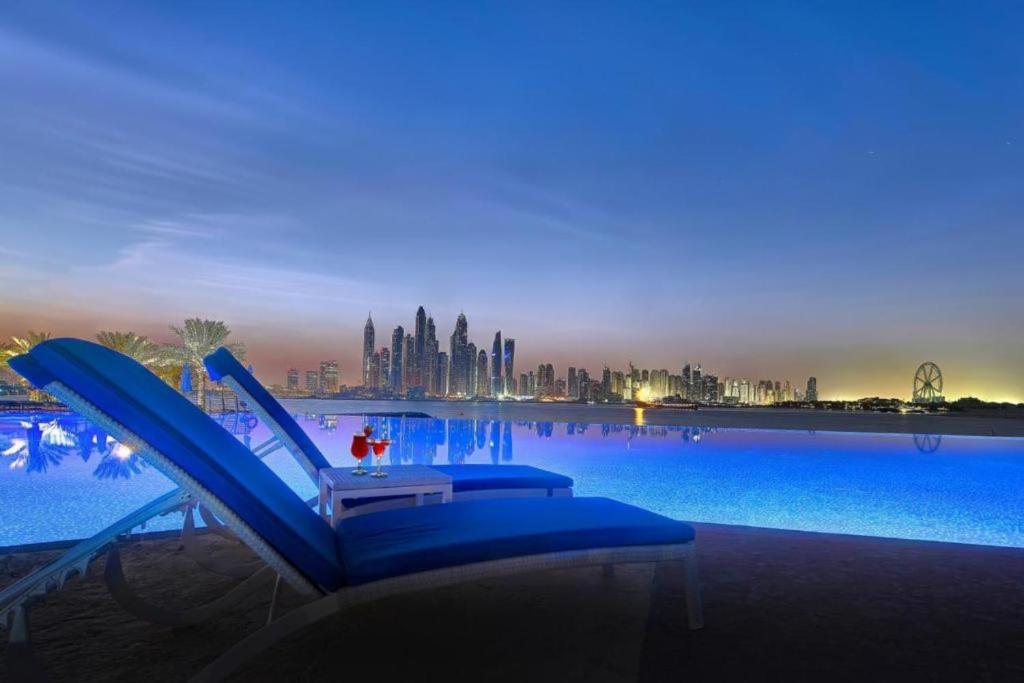 a blue lounge chair sitting next to a large swimming pool at Oceana Residences, Free beach & pool access in Dubai