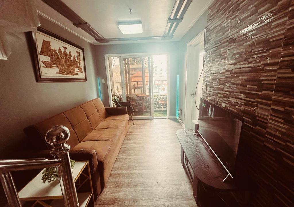 uma sala de estar com um sofá e uma lareira em The Penthouse Zonevill Condo em Baguio