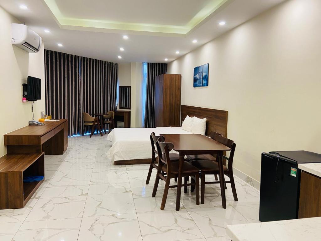 a hotel room with a bed and a table and chairs at MARINA Bình Dương in Ấp Phú Thọ
