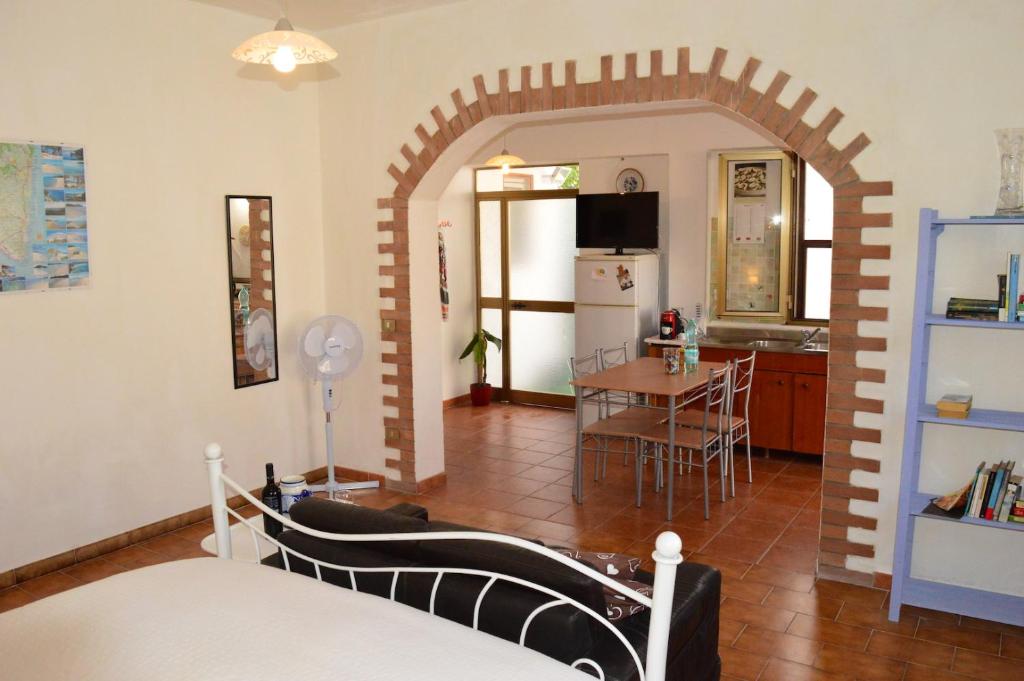 ein Wohnzimmer mit einem Torbogen und eine Küche in der Unterkunft Stefania Guest House in Giba