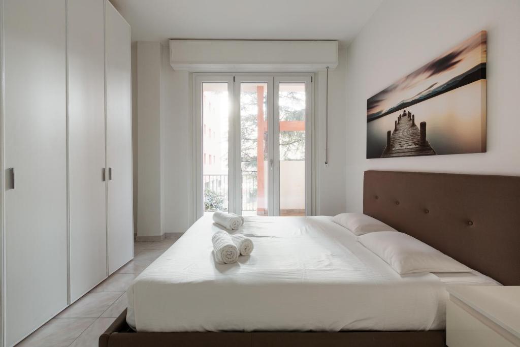 ein Schlafzimmer mit einem großen weißen Bett mit Handtüchern darauf in der Unterkunft Corvetto M3 - Bright Apt. with balcony! in Mailand