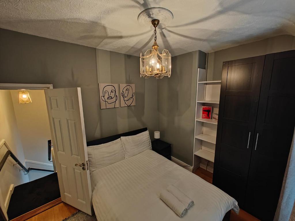 a bedroom with a white bed and a chandelier at Delightful 3 Bed Dublin City House in Dublin