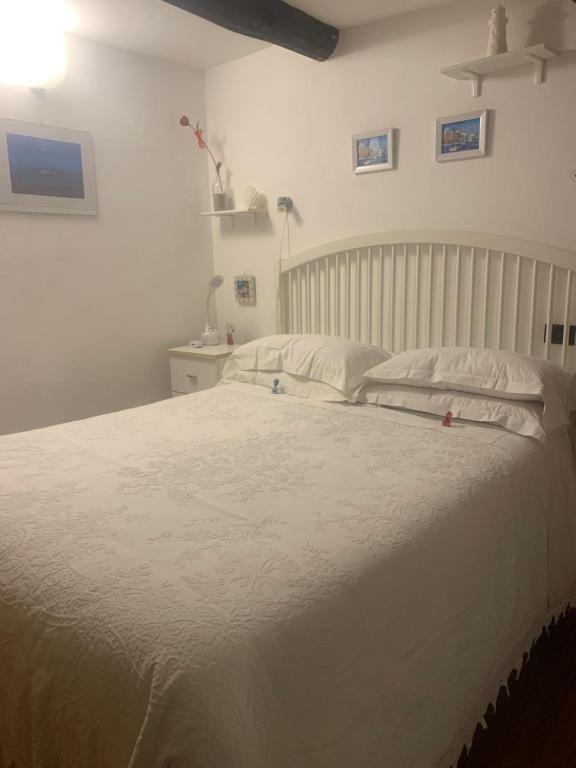 a bedroom with a white bed with white sheets and pillows at BeB CASABARBARA a due passi dal mare in Lerici