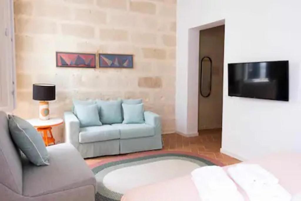 a living room with a couch and a tv at Suite 2 in Mahón