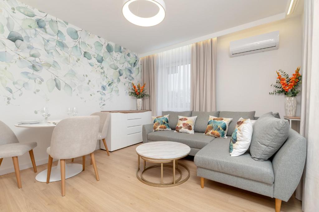 uma sala de estar com um sofá e uma mesa em Bright Apartment with Spacious Balcony and Air Conditioning by Renters em Rzeszów