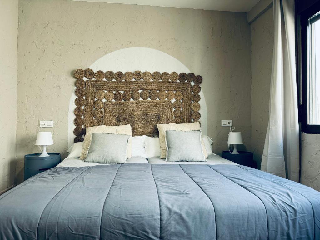 ein großes Bett mit einem großen Kopfteil in einem Schlafzimmer in der Unterkunft Vistas al Mar, Piscina y Playa in Alicante