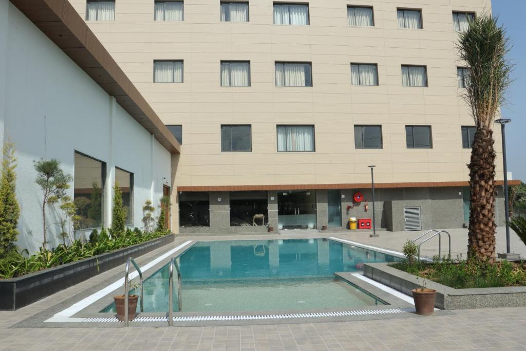 einem Pool vor einem Gebäude in der Unterkunft Crown Park Luxury Hotel in Bhīlwāra