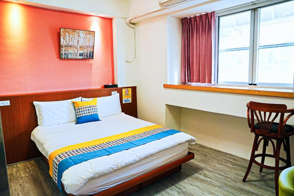 um pequeno quarto com uma cama e uma janela em The Wind B&B em Budai