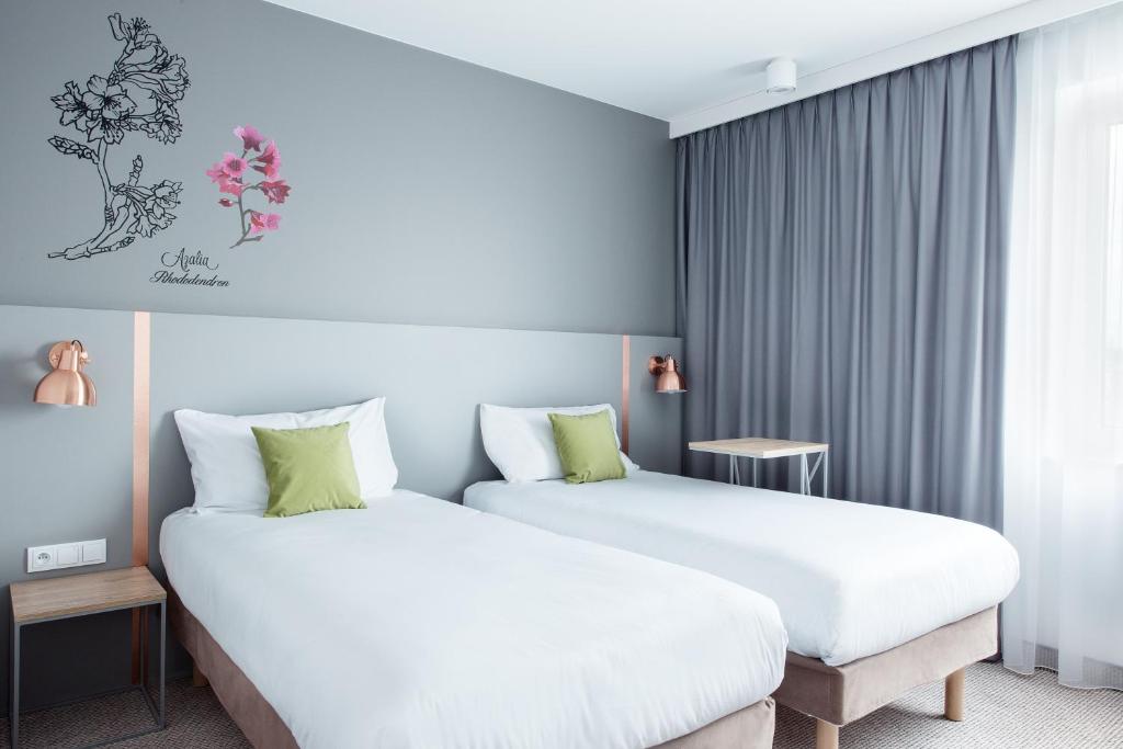 um quarto de hotel com duas camas e uma janela em ibis Styles Siedlce em Siedlce