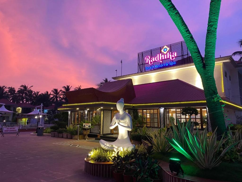 un edificio con una estatua delante de él por la noche en Radhika Beach Resort & Spa Diu, en Nagwa