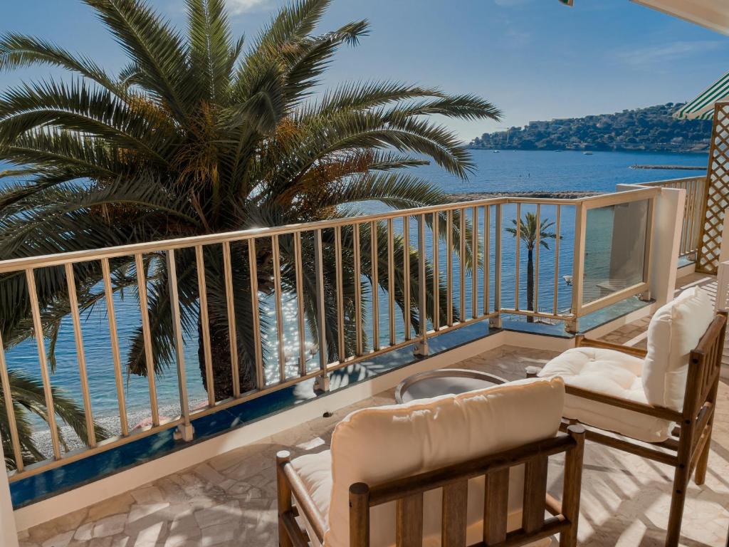 a balcony with chairs and a view of the ocean at Soleil Riviera Apartament Côte d’Azur in Roquebrune-Cap-Martin