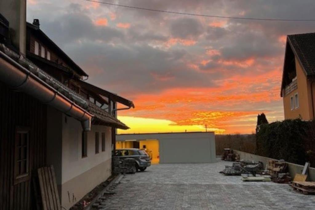 une voiture garée sur un parking avec un coucher de soleil dans l'établissement Die Wohnung auf dem Hägelberg, à Steinen