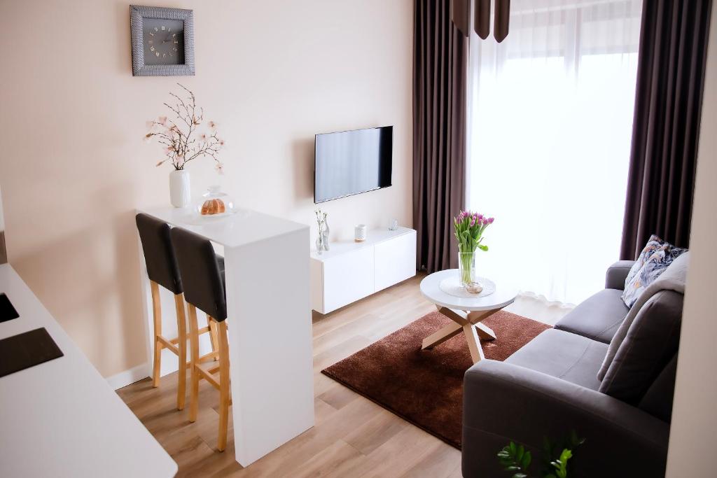 a living room with a couch and a table with a tv at Apartament Bimba - Free Parking in Poznań