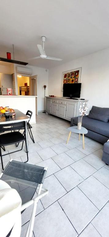 un salon avec un canapé bleu et une table dans l'établissement Le Petit Nénuphar plage et commerces à 400 m, au Grau-du-Roi