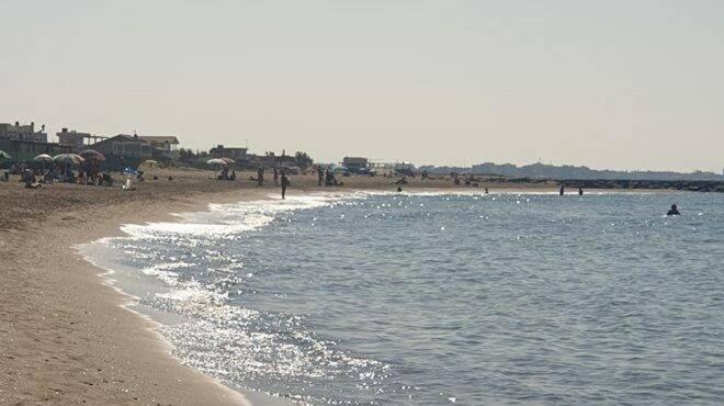 eine Gruppe von Menschen an einem Strand in der Nähe des Wassers in der Unterkunft Il Focolare in Focene