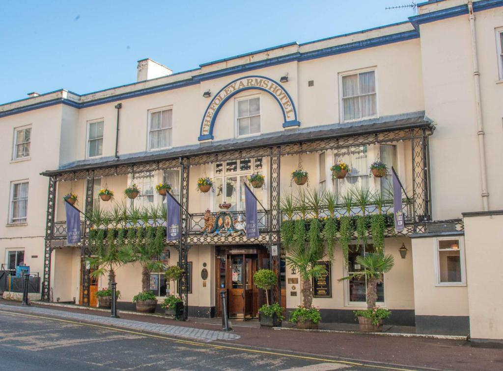 un edificio con plantas al lado de una calle en The Foley Arms Hotel Wetherspoon en Great Malvern