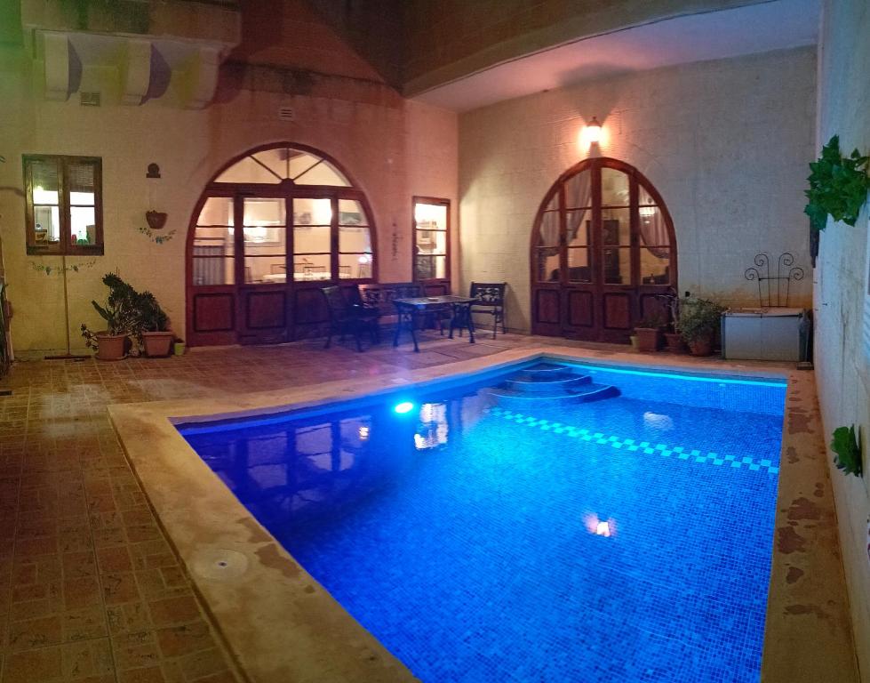 uma grande piscina num edifício com uma piscina azul em Arthome - guest rooms em Gharb