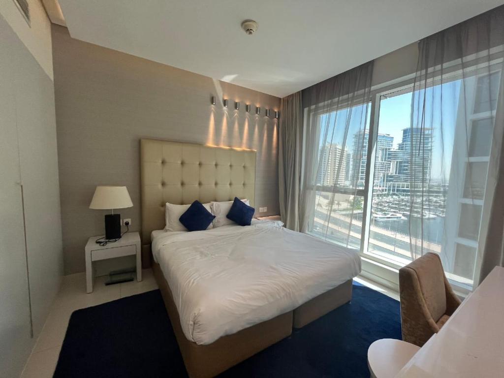 a bedroom with a large bed and a large window at DAMAC Voleo In Business Bay in Dubai