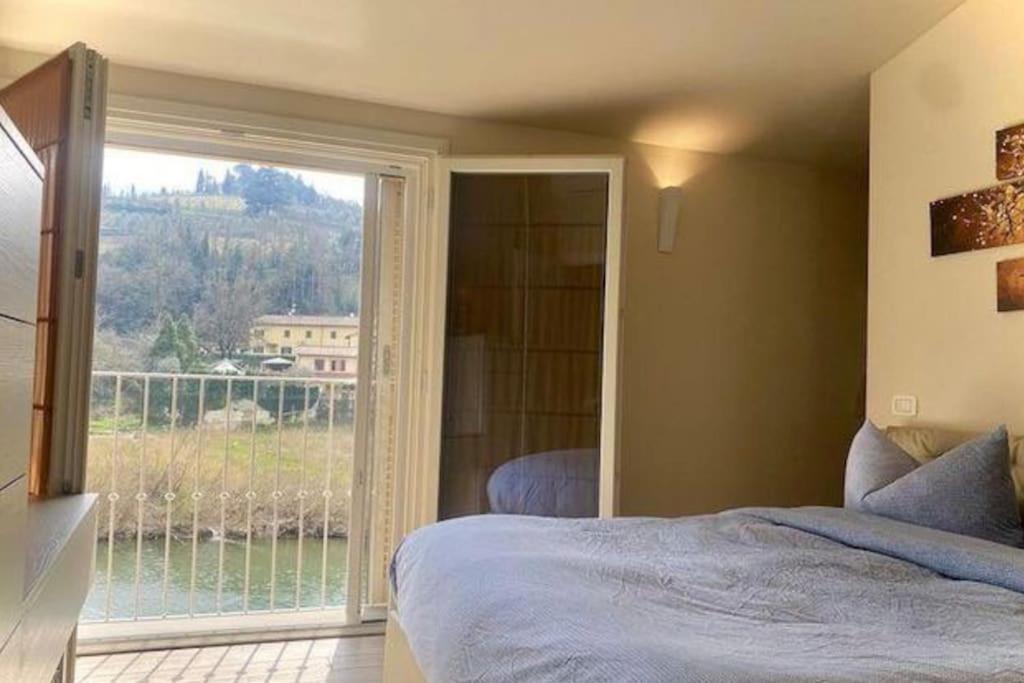 1 dormitorio con cama y ventana grande en House on the river Arno, en Ellera