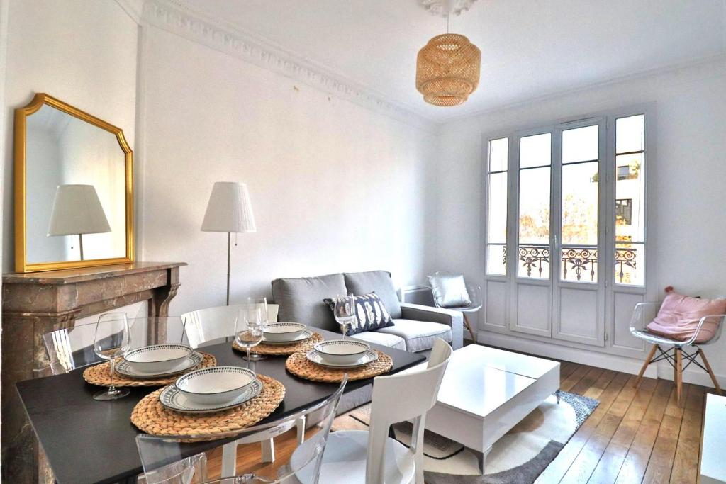 un salon avec une table et un canapé dans l'établissement Escale Urbaine: Confort & Métro à 2 Pas, à Saint-Ouen