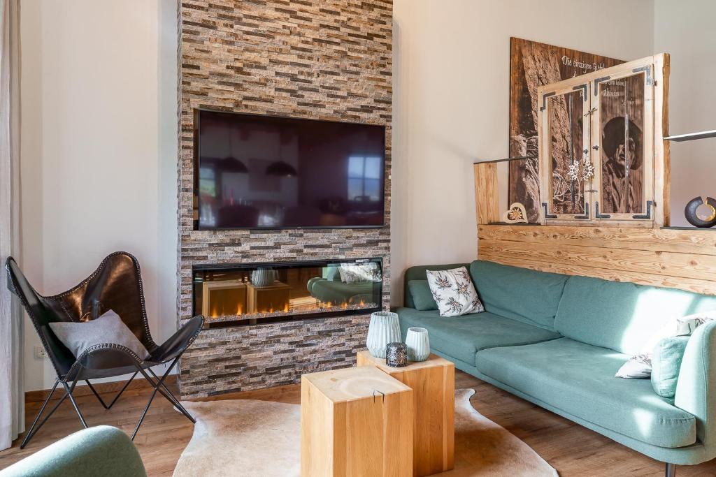 a living room with a couch and a fireplace at Chalet Edelweiss in Niedernsill