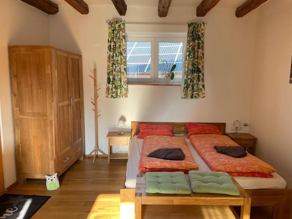 a bedroom with a large bed with red pillows at Ferienwohnung Oma Else in Offenheim
